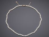 a white pearl necklace with a gold clasp
