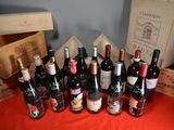 many bottles of wine sitting on a table next to boxes of wine