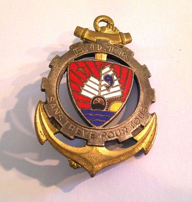 a badge on a white table with a gold anchor