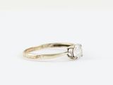 a close up of a white diamond ring on a white surface