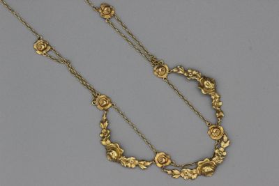 un gros plan d'un collier en or orné de fleurs
