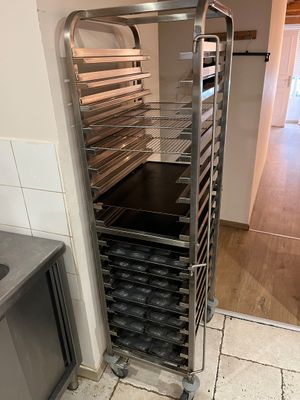 une étagère métallique avec des plateaux de nourriture dans une cuisine