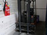 un chariot élévateur dans un garage où un extincteur est accroché au mur