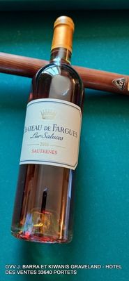 une bouteille de vin posée sur une table de billard, à côté d'une queue de billard
