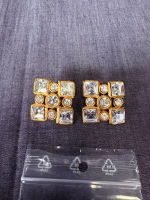 une paire de boucles d'oreilles dorées ornées de cristaux transparents