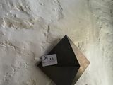 a small black object on the wall of a building
