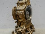 une horloge en or posée sur une table blanche