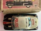 une petite voiture de police miniature et une boîte posées sur une table