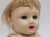 a close up of a doll with a broken arm