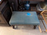 a blue and white striped foot stool in a room