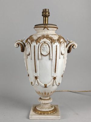 un vase blanc orné d'une horloge, posé sur une table