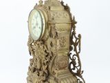 a gold clock sitting on top of a table