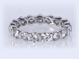 a close up of a diamond eternity ring on a white background