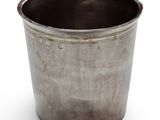 a metal cup that is sitting on a white surface