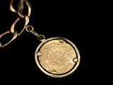 gold coin on a chain on a black background