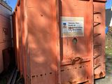 une benne à ordures orange posée au milieu d'une cour