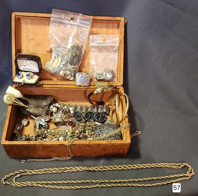 a wooden box filled with jewelry on a table