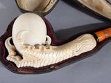 a pipe and a skull in a case on a table