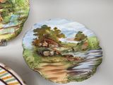 three plates with a painting of a farm scene on them