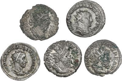 quatre pièces de monnaie romaines anciennes, dont l'une représente la tête d'un homme