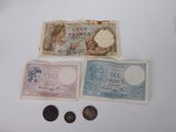three different bank notes and a coin on a table