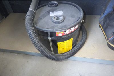 un aspirateur posé par terre à côté d'un sac