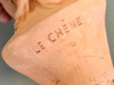 a person that is holding a wooden vase with writing on it