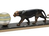 statue représentant un chat noir et un œuf, posée sur un socle en marbre