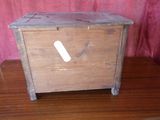 a small wooden box on a table with a red curtain in the background