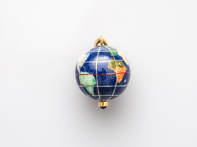 a blue and gold globe ornament hanging on a white wall