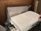 un homme debout à côté d'un lit dans une chambre