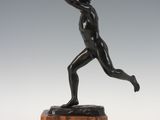 an image of a bronze statue of a man throwing a frisbee