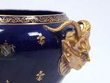 a large blue vase with a gold lion head on it