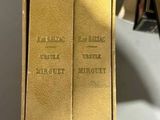 two books are sitting in a box on a table next to each other