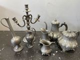 un ensemble de vases en argent et un candélabre posés sur une table