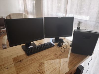 deux écrans d'ordinateur et un clavier sur un bureau