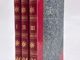 three books are stacked on top of each other on a white surface