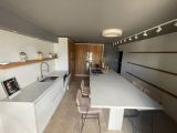 une cuisine avec une table et des chaises au milieu