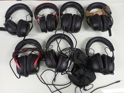 several black headphones are lined up on a white table