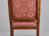 an antique wooden chair with a pink upholstered seat