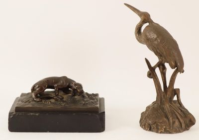 a bronze statue of a bird and a dog on a stand