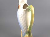 a white bird sitting on top of a green vase