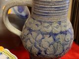 a blue and white vase sitting on a table next to a plate