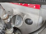 a close up of a motorcycle engine with a hose attached to it