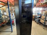 an image of a black refrigerator in a warehouse