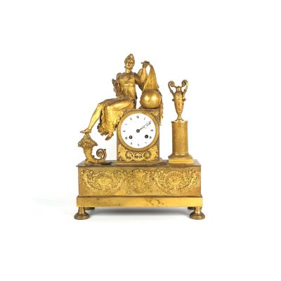 une horloge en or surmontée d'une statue