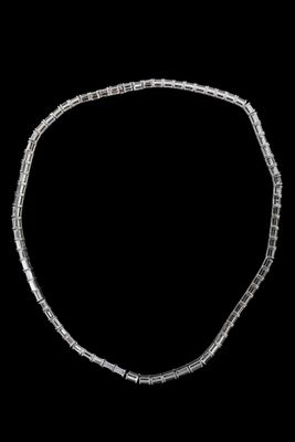 un gros plan d'un collier en argent sur fond noir
