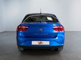 the rear end of a blue car in a white room