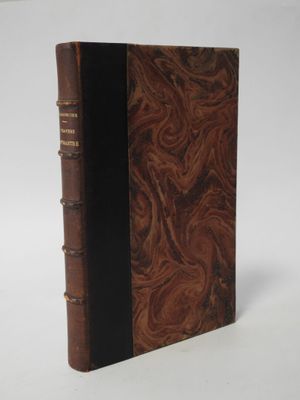 an old book sitting on top of a white table next to a white wall