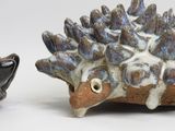 a small ceramic hedge sitting next to a smaller ceramic hedge